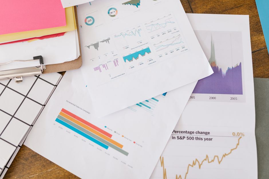 Business analytics charts and performance metrics on printed report pages.